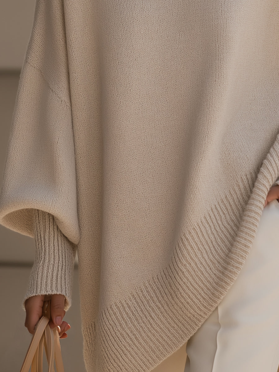 Beige oversized poncho with ribbed hem and cozy knit cuff at sleeve