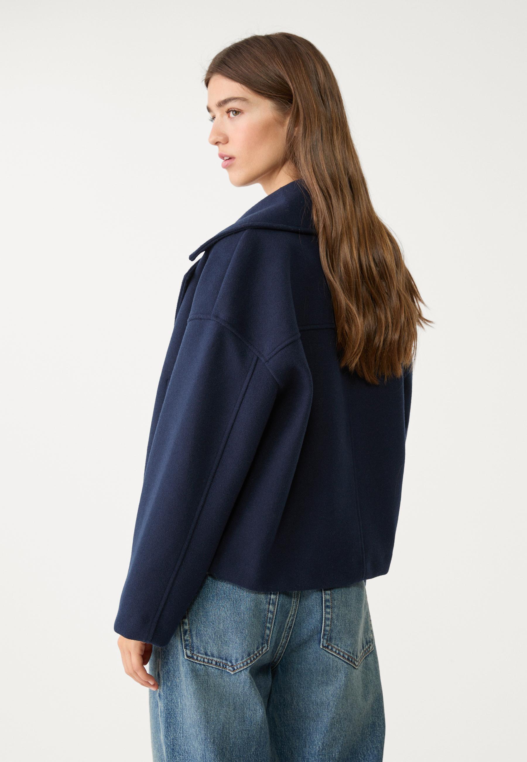 Navy boxy cropped double-breasted blazer side view with structured shoulders