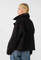 Back view of black boxy cropped double-breasted blazer with stand collar
