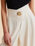 Cream wide-leg tailored pants with gold statement button detail