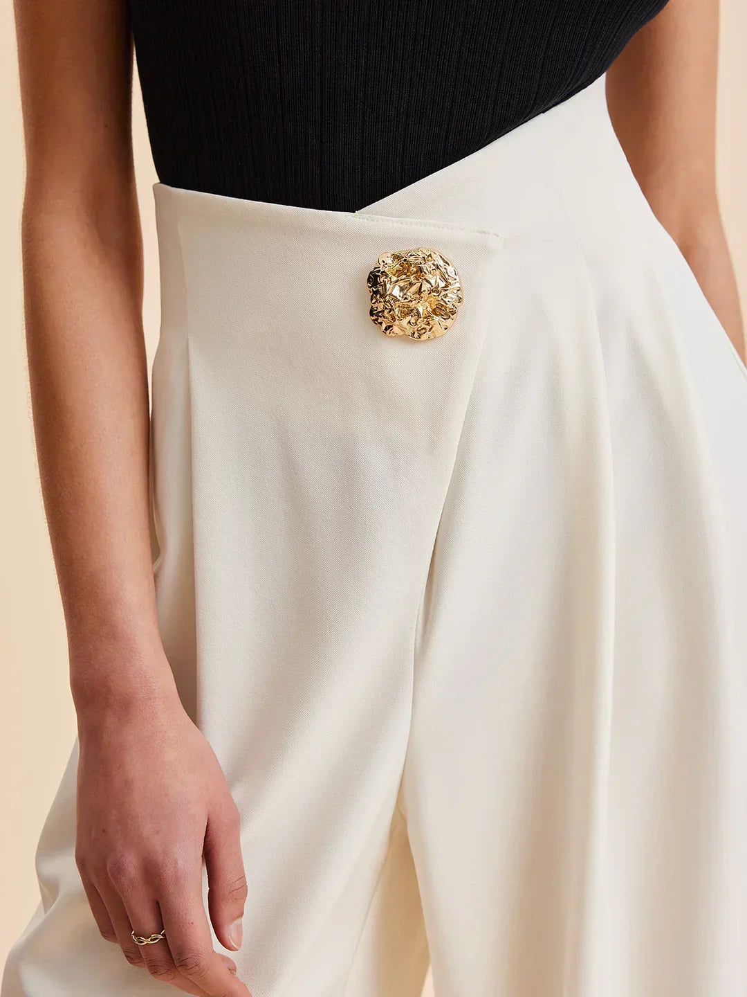 Cream wide-leg tailored pants with gold statement button detail