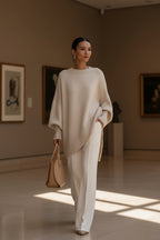 Cream oversized knit poncho with ribbed crew neck and wide folded sleeves