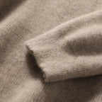 Heathered knit fabric close-up on a women’s pullover hoodie in warm taupe
