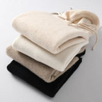 Folded women’s pullover hoodies with drawstrings and ribbed cuffs in light neutrals