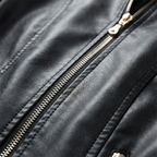 Black leather biker jacket with front zipper and metal pull close-up