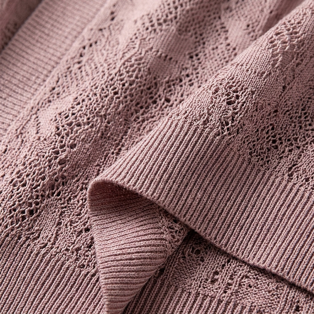 Cropped lace knit cardigan with openwork lace panels and ribbed cuff detail in light pink