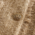 Brown tweed cropped jacket button close-up with ornate gold-tone detail