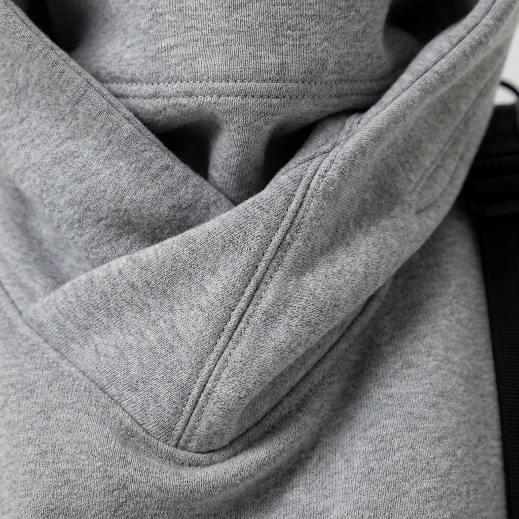 Grey oversized hoodie front pocket and hood lining edge, close-up