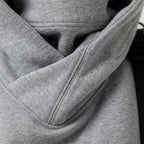 Grey oversized hoodie front pocket and hood lining edge, close-up
