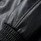 Black oversized bomber jacket sleeve cuff with ribbed elastic trim and seam detail
