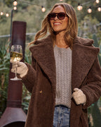 Brown teddy coat close-up: plush teddy fabric, side pockets, open front