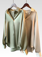 Satin-style button-up shirt blouses in olive green and champagne on hangers, pointed collars
