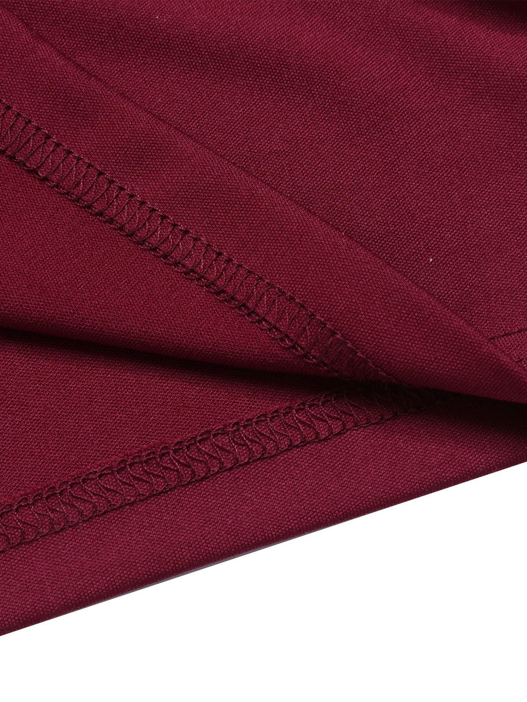 Close-up of wine red fabric seam with stitched trim along the waistband