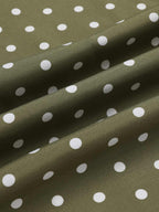 Green polka dot woven fabric close-up with smooth drape