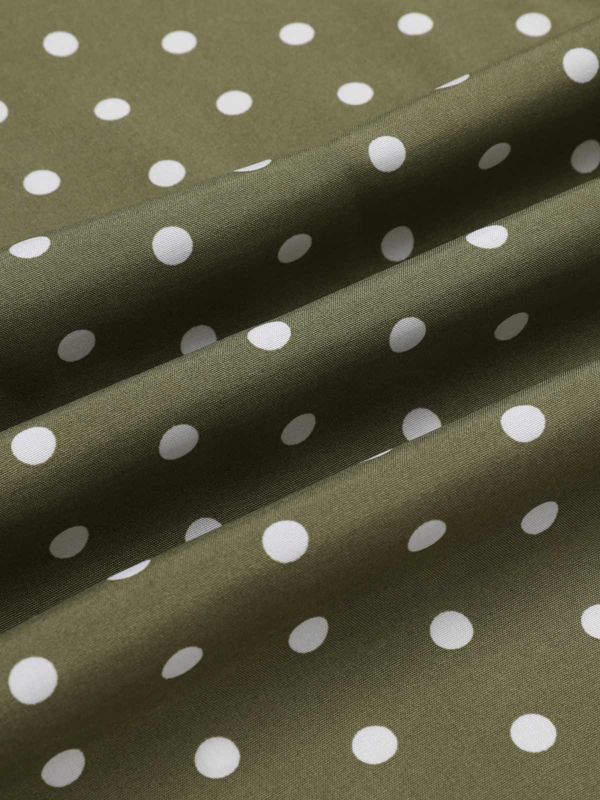 Green polka dot woven fabric close-up with smooth drape