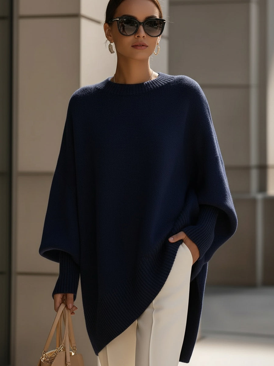 Navy blue oversized knit poncho with ribbed neckline and wide sleeve shape