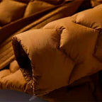 Quilted down coat pocket and belt edge in amber orange with diamond quilting