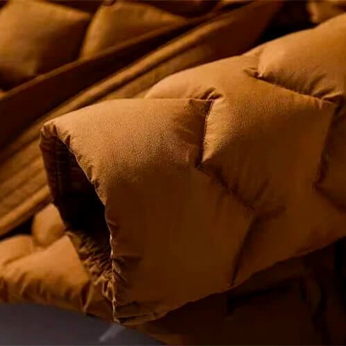 Quilted down coat pocket and belt edge in amber orange with diamond quilting
