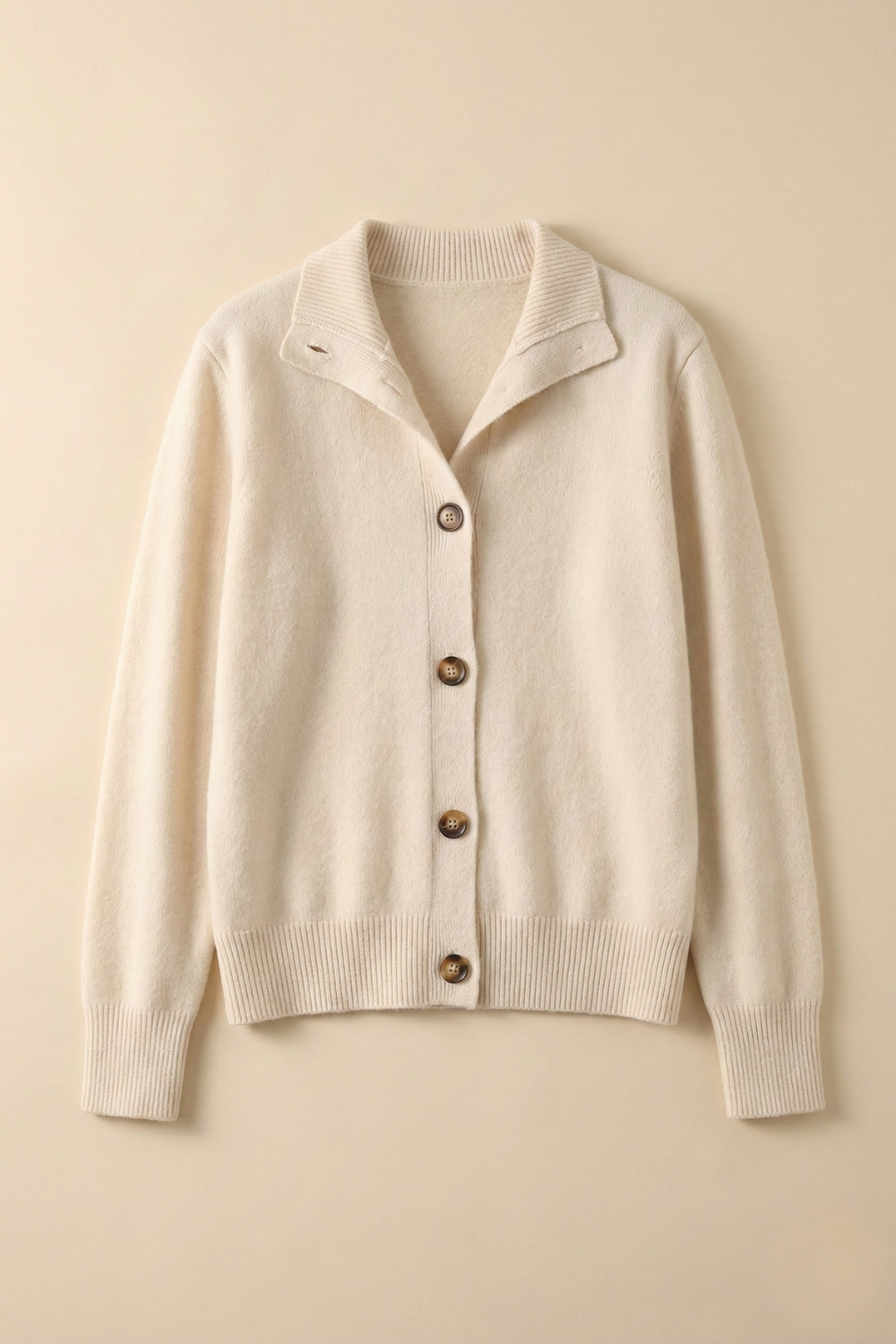 Ivory button cardigan sweater with collared neckline and ribbed cuffs.