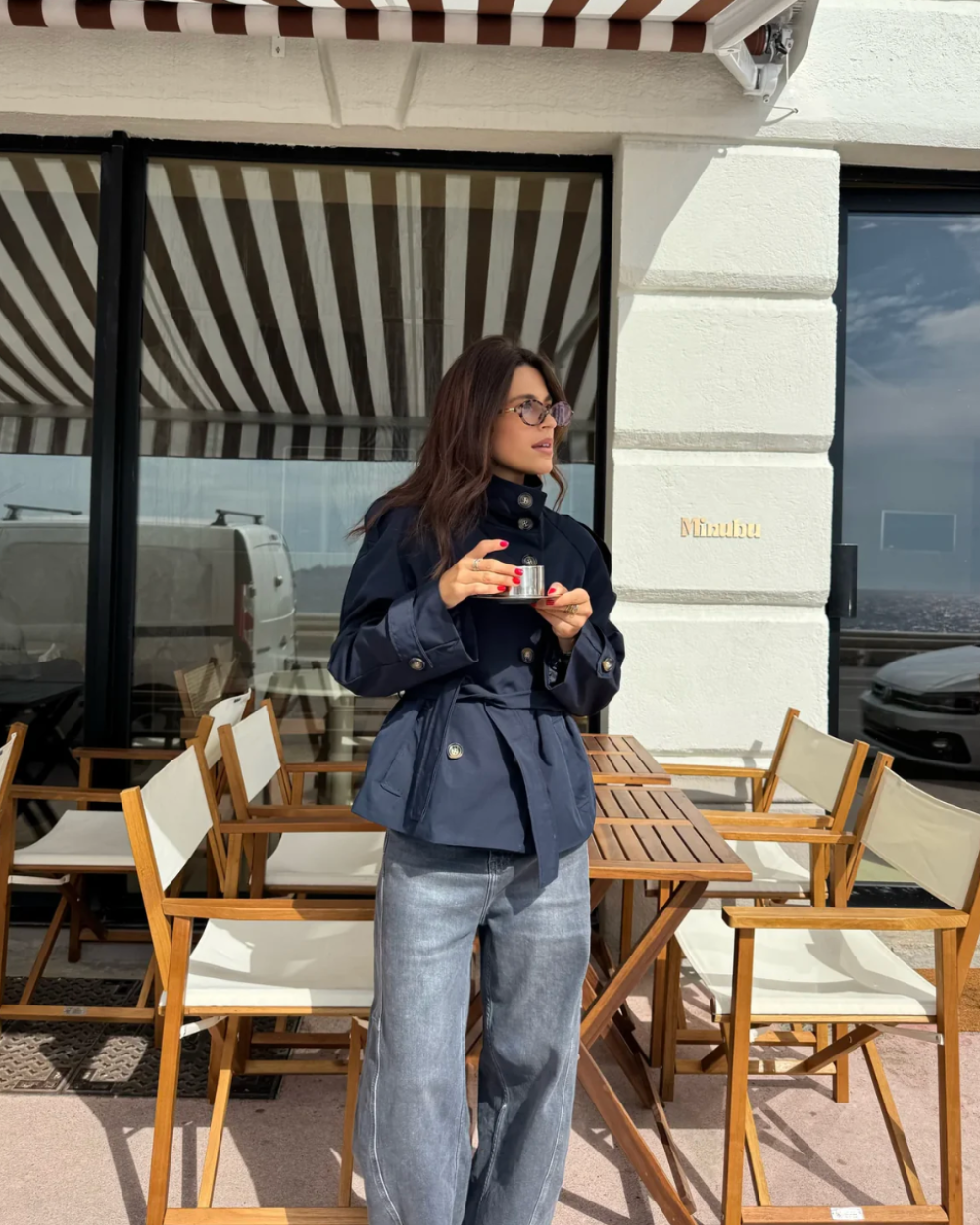Navy cropped trench coat with belted waist and buttoned front