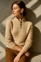 Light cream cable-knit cashmere button-up sweater with black-button placket and ribbed cuffs.