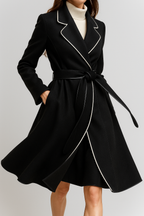 Womens long black overcoat with notched trim, belt tie, and contrast piping