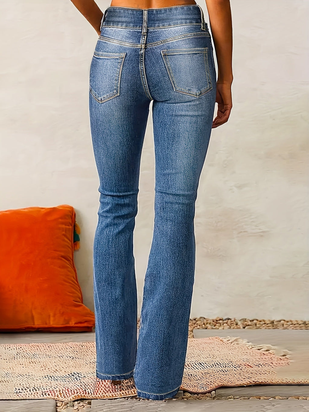 Denim blue high-waisted flared jeans, back view with belt loops and rear pockets