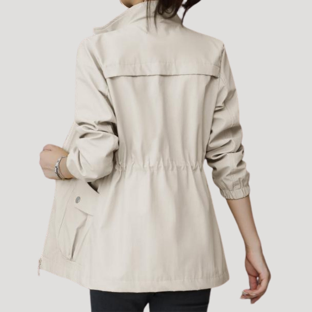 Light beige women’s windbreaker jacket, back view with elastic cuffs and yoke seam