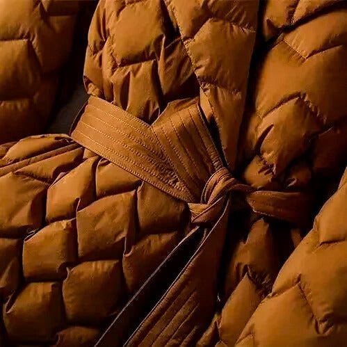 Quilted down coat chest detail in amber orange with tie-belt and diamond quilting