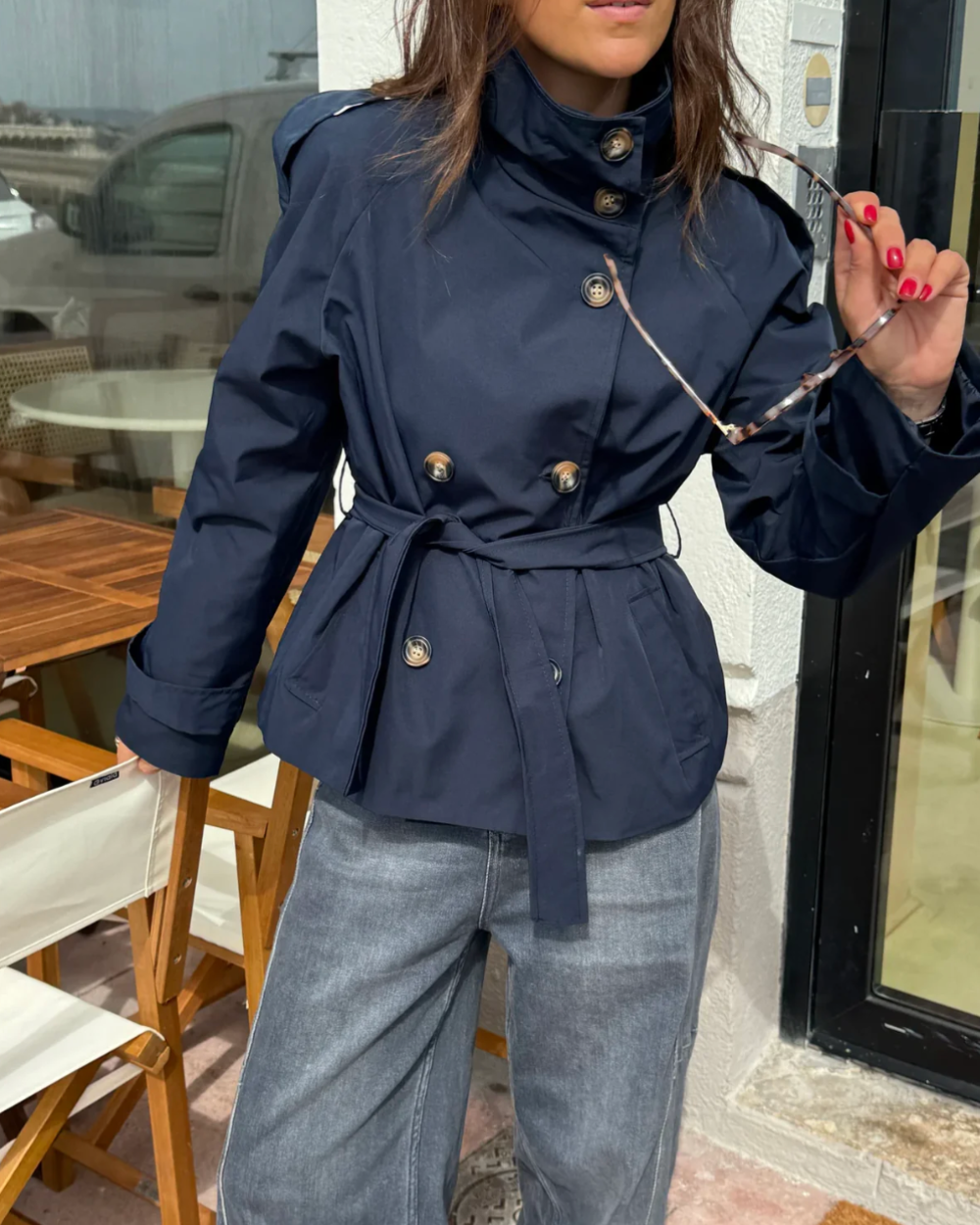 Navy cropped trench coat with high collar, button details, and waist tie
