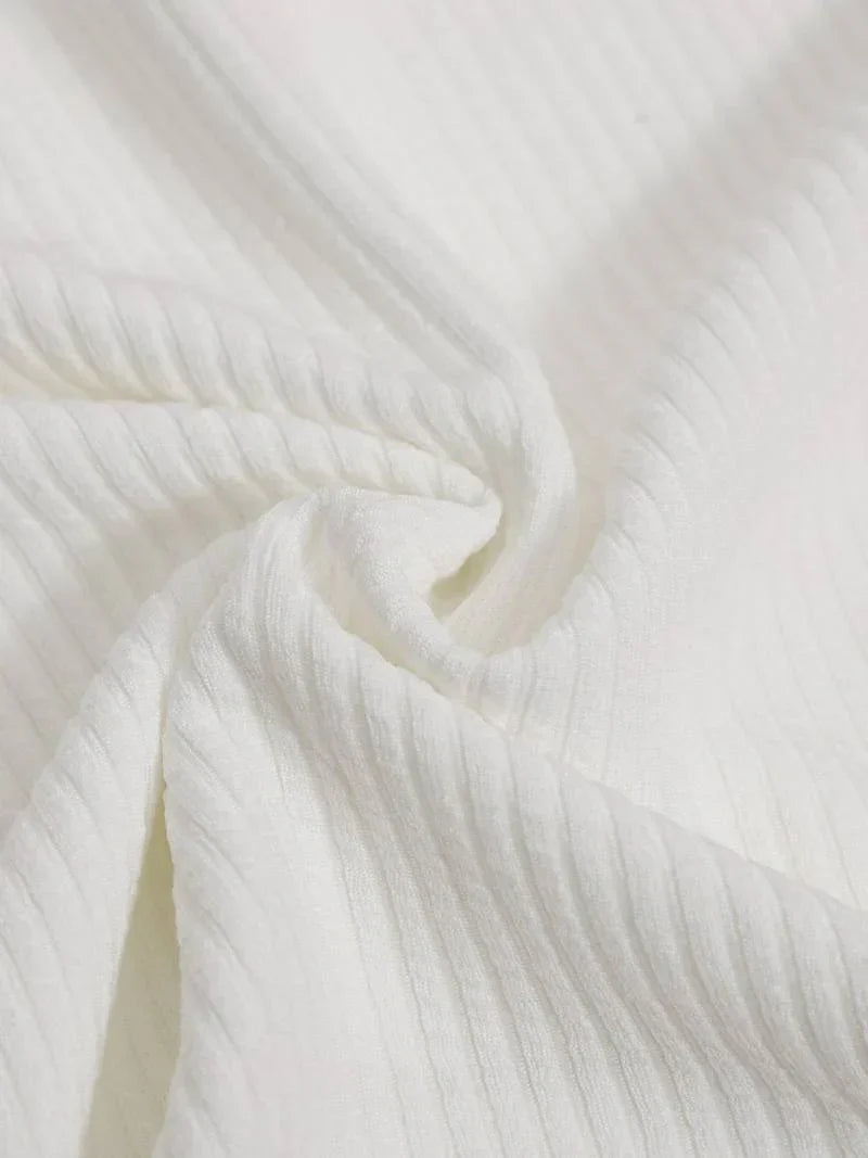 White ribbed knit polo fabric on a long-sleeve top, close-up texture