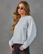Heather grey crewneck knit sweater with long, loose sleeves and ribbed hem