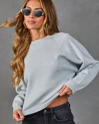Heather grey crewneck knit sweater with long sleeves and ribbed cuff