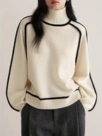 Cream turtleneck knit sweater with black-trim neckline and cuffs