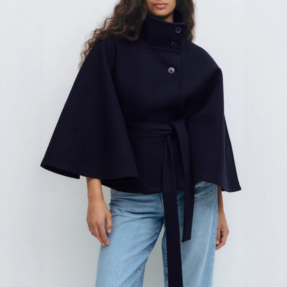 Women's high-collar cape coat in navy, front view with belt tie and buttoned collar