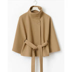 Women's high-collar cape coat in tan, front view with button placket and belt tie