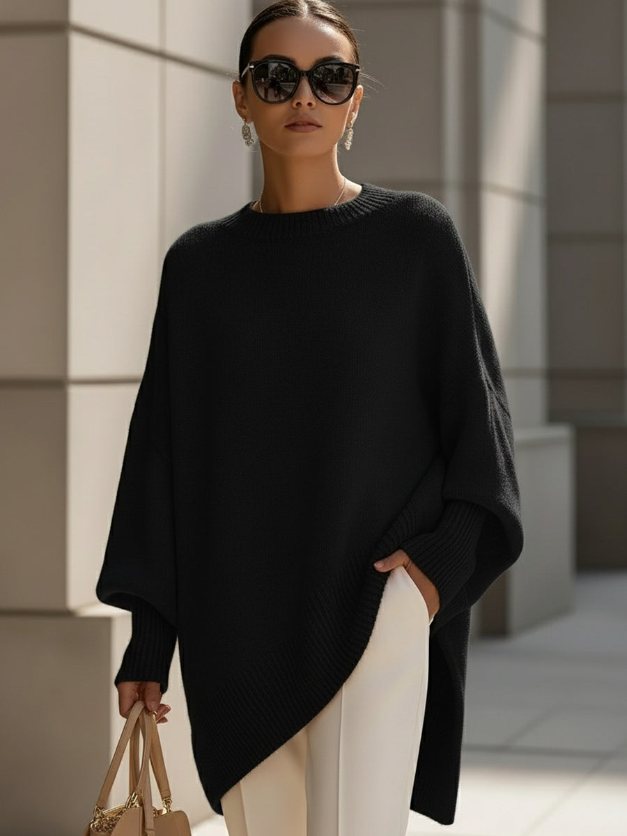 Black oversized knit poncho with ribbed crew neck and draped asymmetrical hem