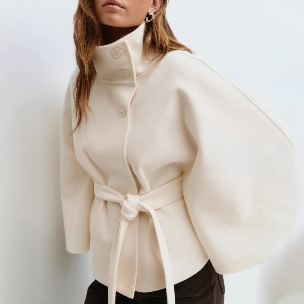 Women's high-collar cape coat in white, front view with belt tie and snap buttons