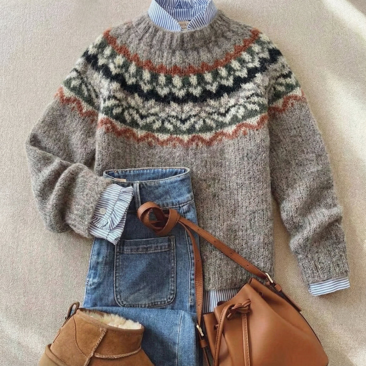 Folded gray knit sweater with Nordic fair isle yoke in dark and orange accents.