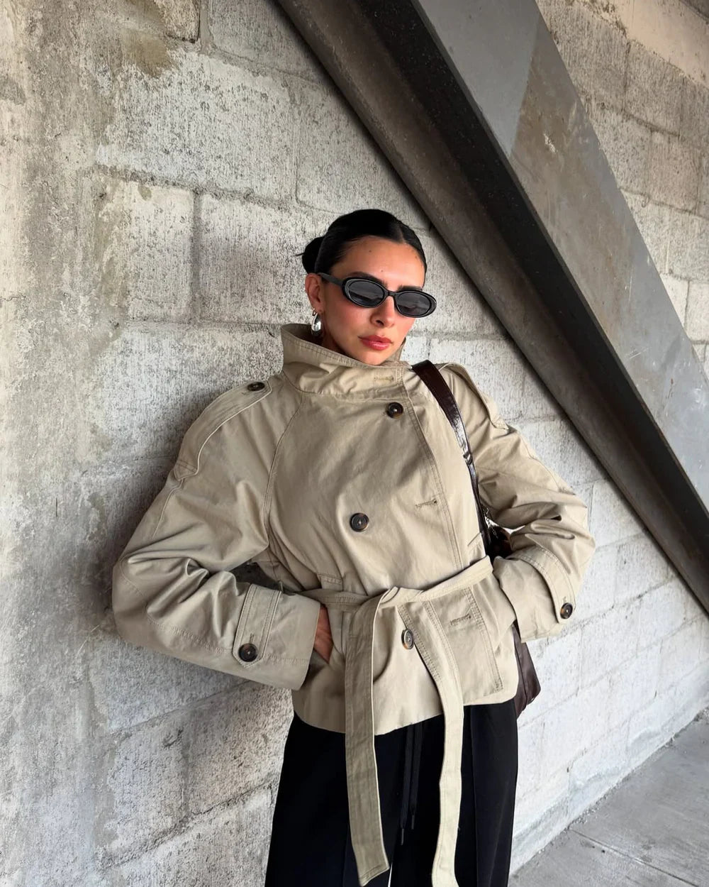 Light khaki cropped trench coat with belted waist and buttoned flap pockets