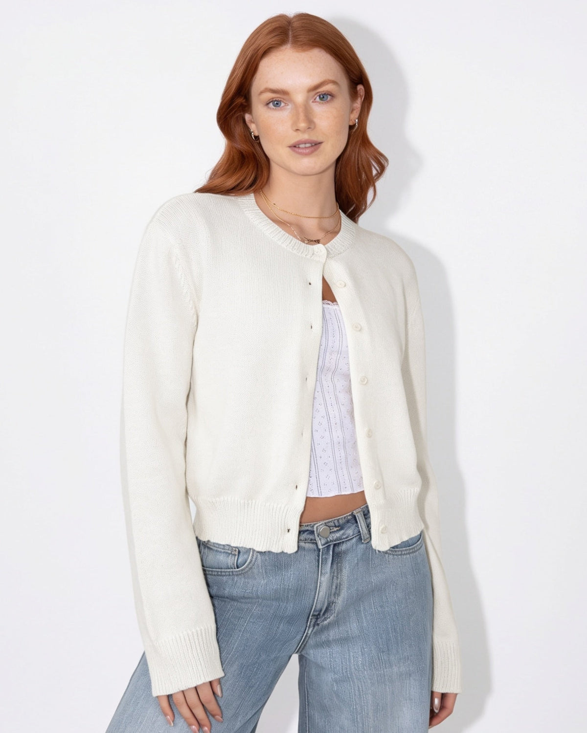 White cropped knit cardigan with round neck and button front, long sleeves