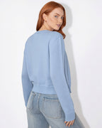 Light blue cropped knit cardigan with round neck, button front, and long sleeves