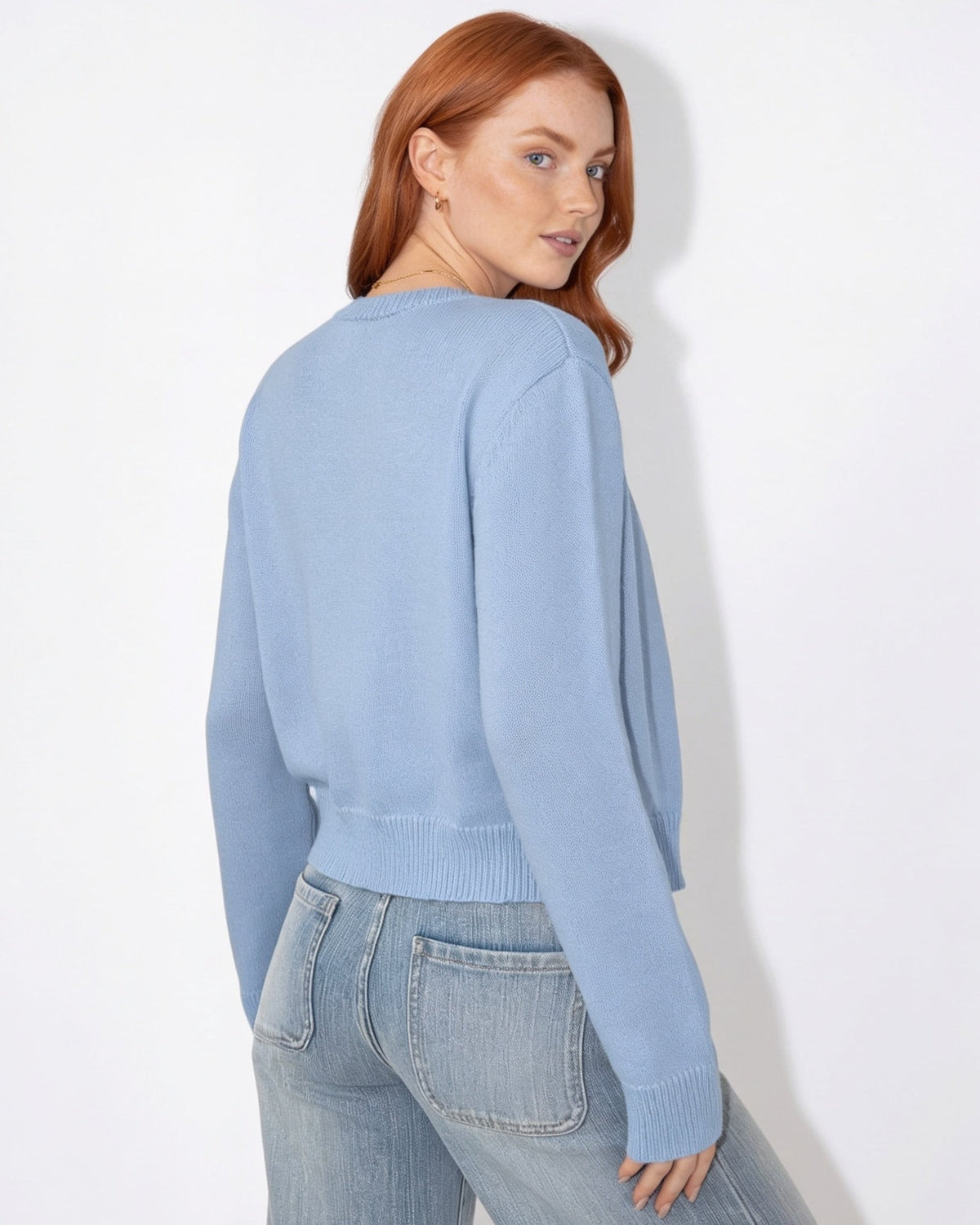 Light blue cropped knit cardigan with round neck, button front, and long sleeves