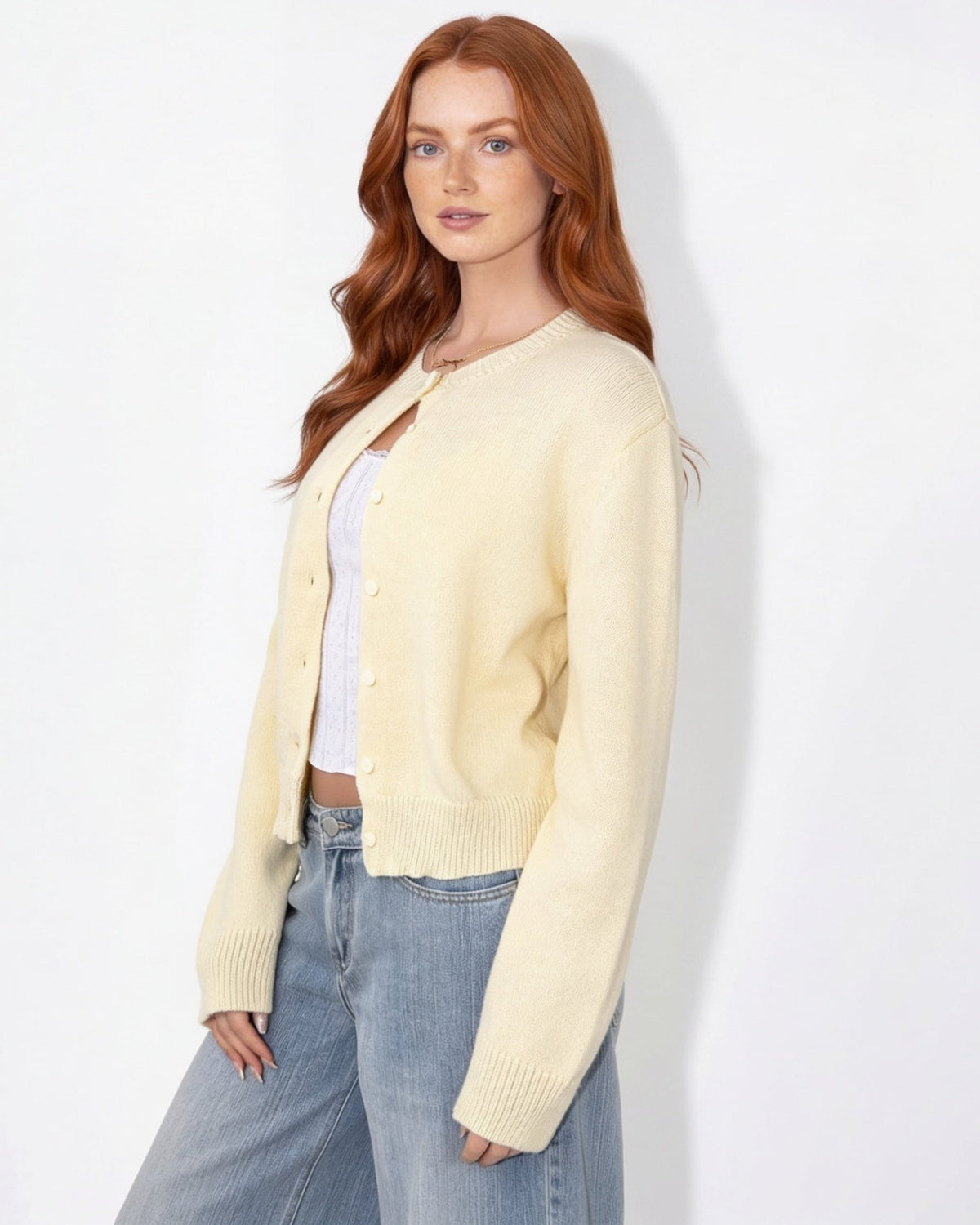Cream cropped knit cardigan with round neck and button front, long sleeves