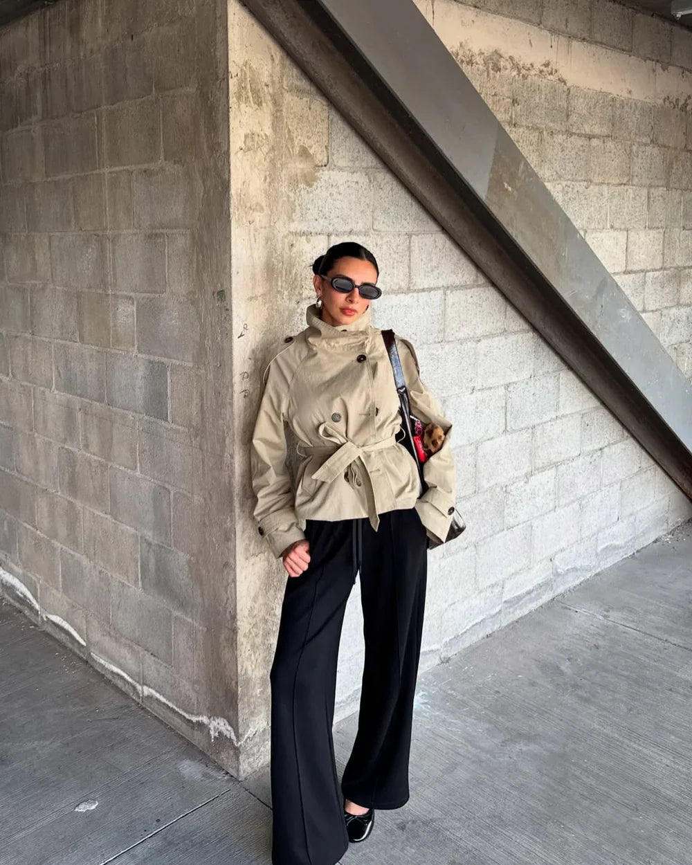 Beige cropped trench coat with high collar, buttoned front, and belt tie