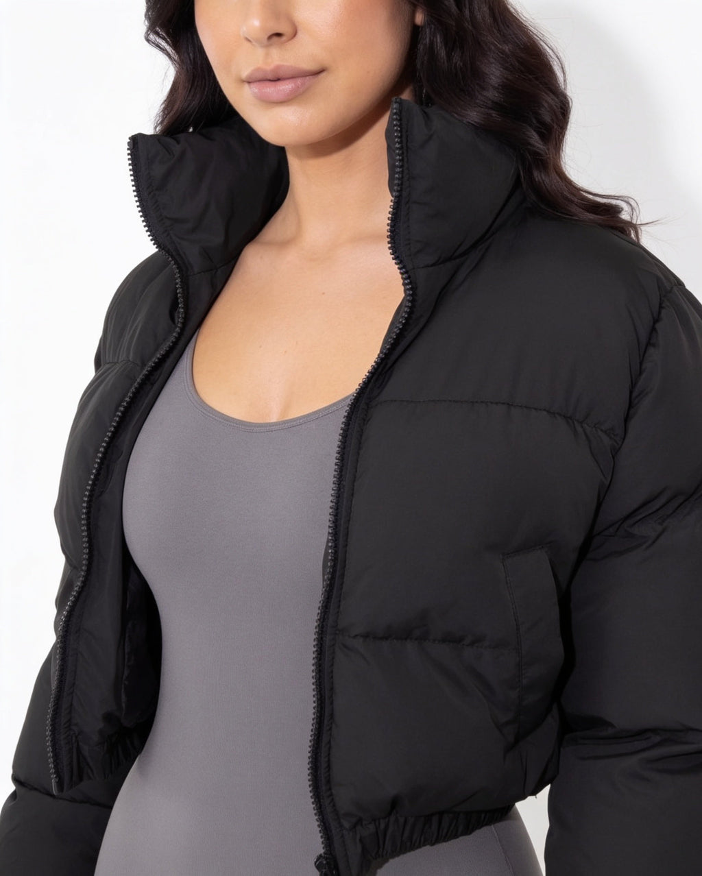 Black cropped puffer jacket close-up with funnel collar and zip front