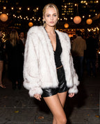 Off-white faux fur hooded jacket with open front, deep collar, and long sleeves.