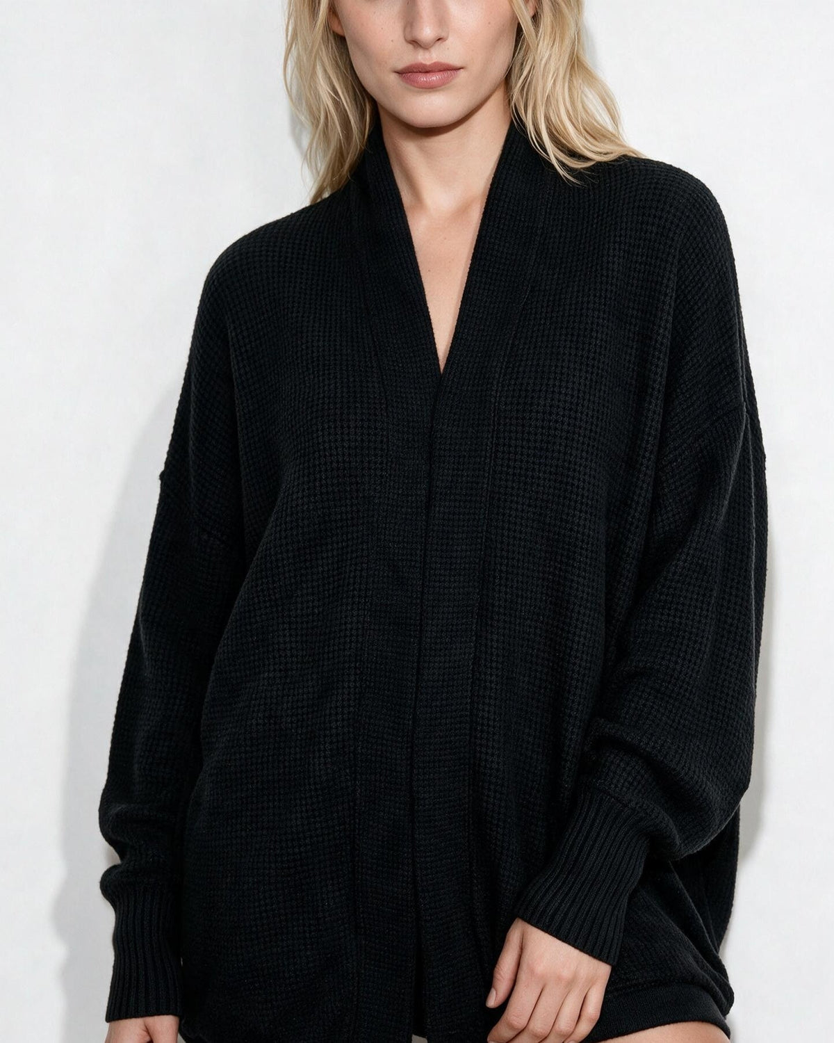 Women’s longline open-front cardigan with dolman sleeves, black knit with ribbed cuffs.