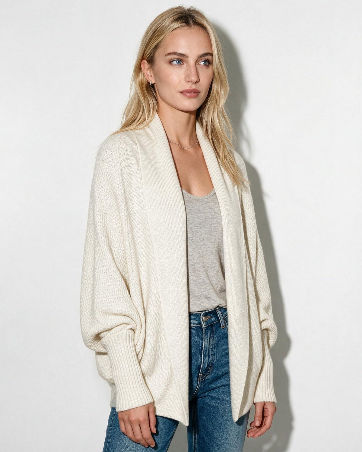 Women’s longline open-front cardigan with dolman sleeves, cream knit texture.