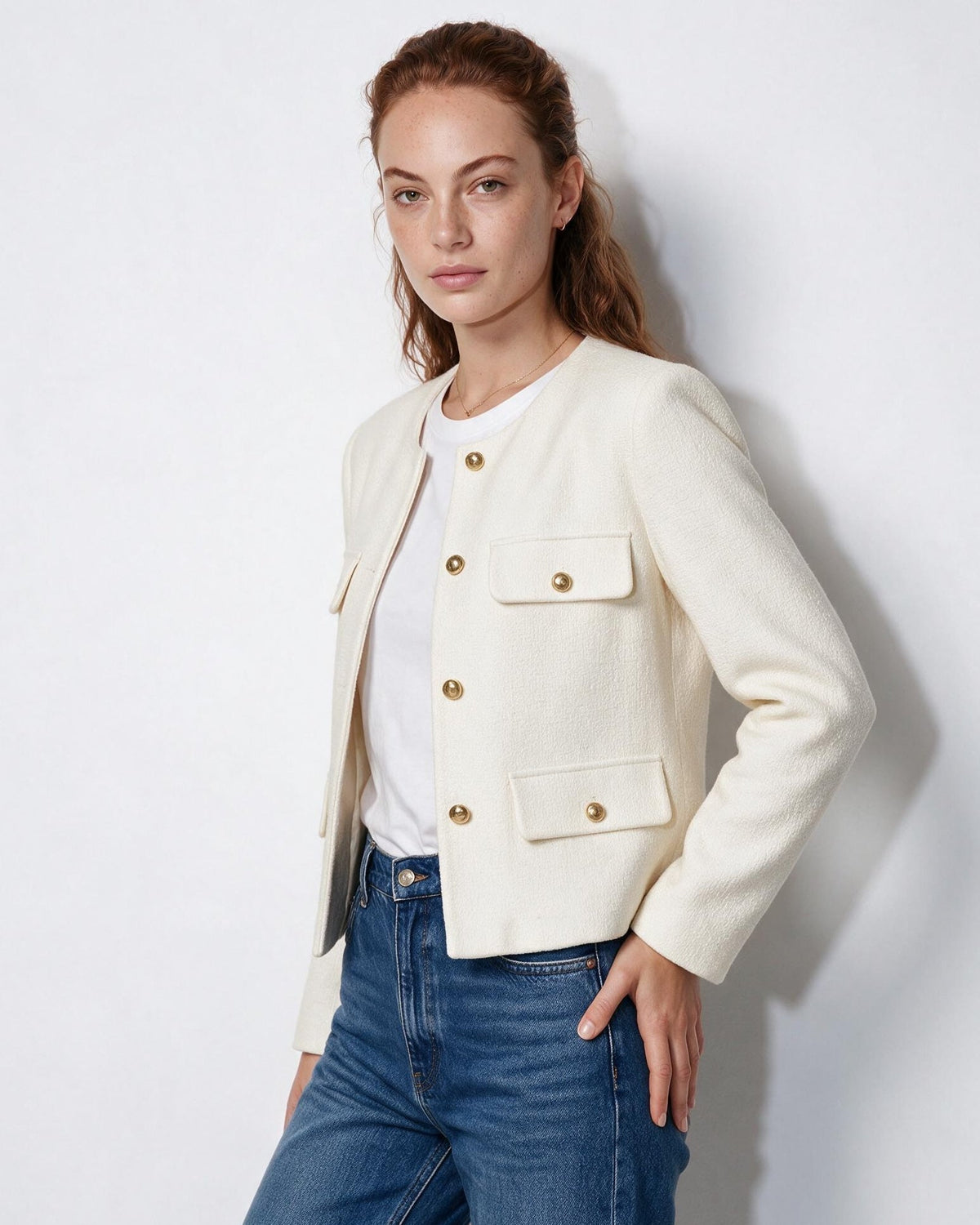 Women’s cream cropped collarless jacket, gold button front with four flap pockets, full view.